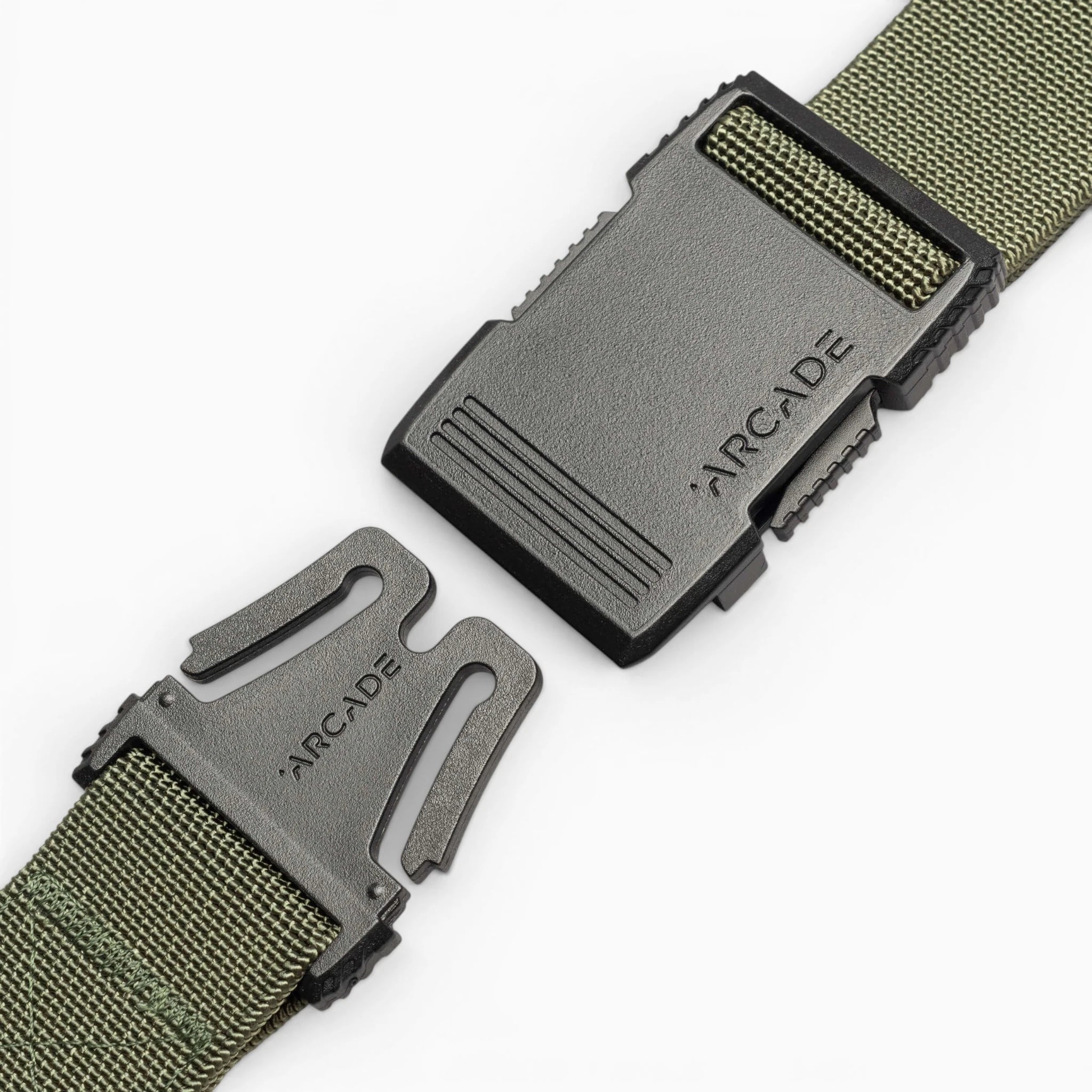 A close-up of the Arcade Belts Hardware, a green woven travel belt with stretch webbing and a black plastic buckle branded ARCADE on both halves, partially unfastened on a white background.