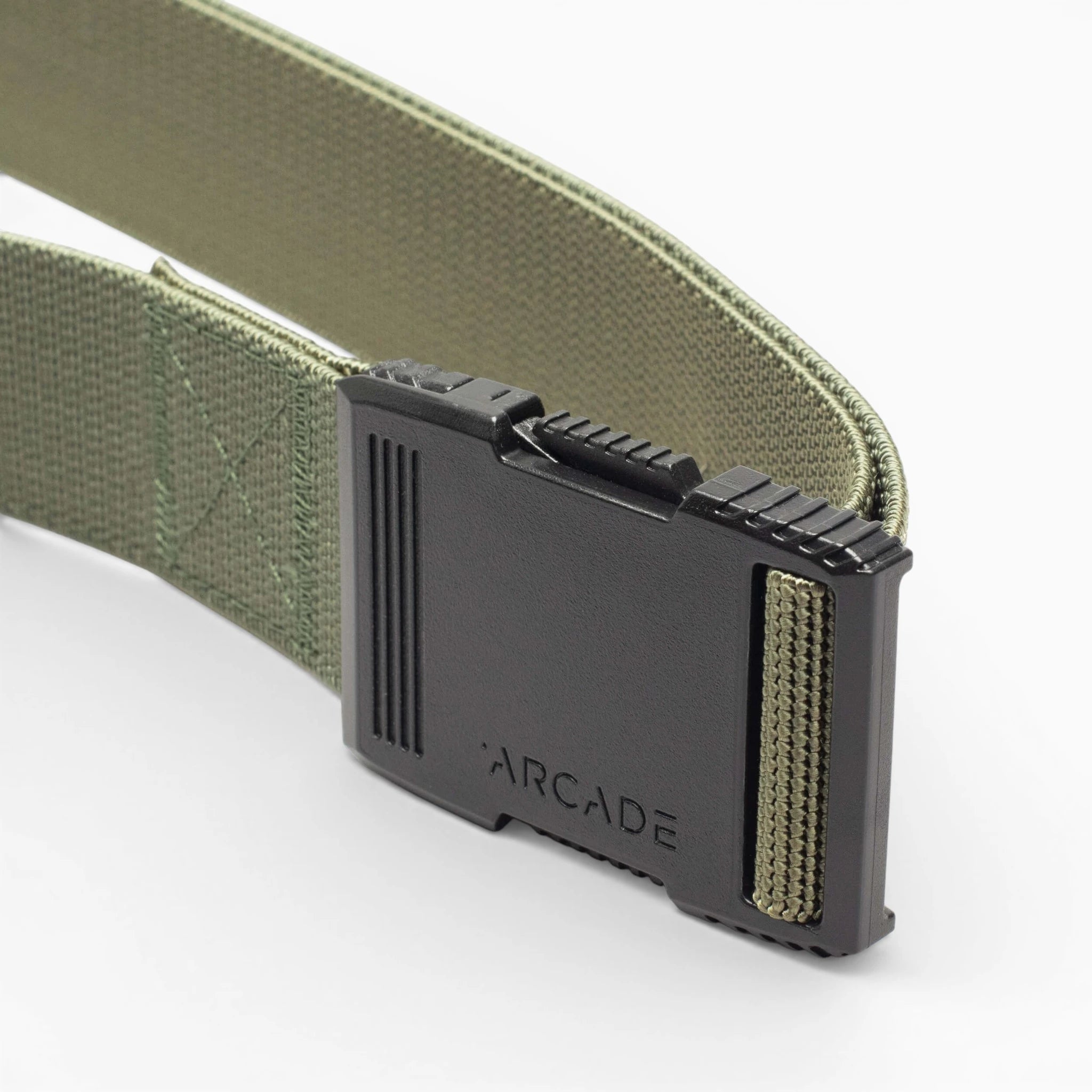 A close-up of the olive green Arcade Belts Hardware with a low-profile, black plastic buckle featuring ridged edges and ARCADE engraved on it, set against a plain white background.