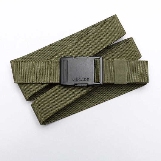 The Arcade Belts Hardware is an olive green stretch belt with a black plastic buckle embossed ARCADE, ideal for travel. Shown on a white background.