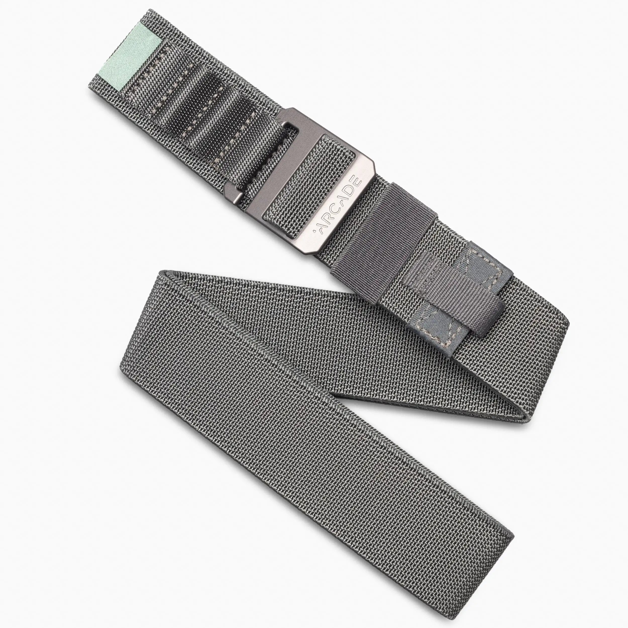The Arcade Belts Hardware Alu Long Kit features gray woven stretch webbing, a black metal buckle, black stitching, and a mint green accent on one end—ideal for travel or everyday wear. Shown on a white background.