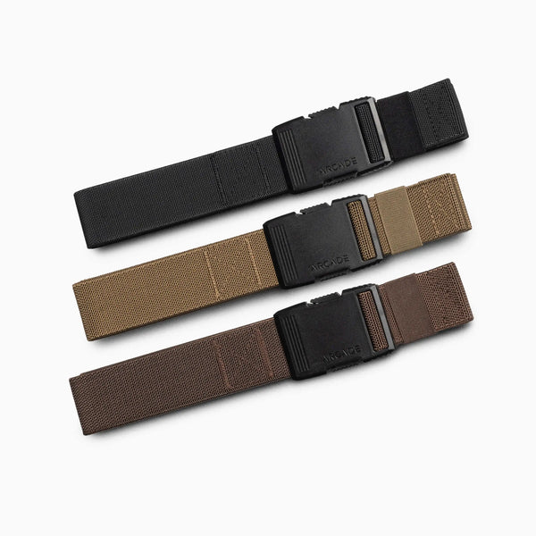 Three Arcade Belts Hardware Kits, each featuring a black plastic buckle and stretch webbing, are arranged horizontally on a white background in black, tan, and brown from top to bottom.