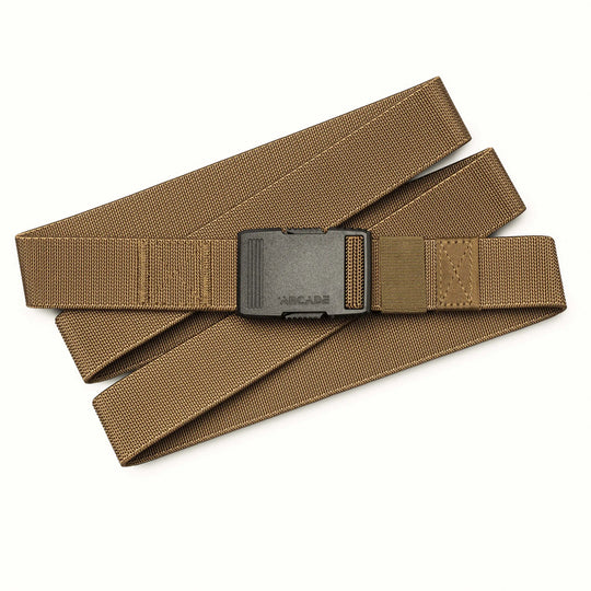 The Arcade Belts Hardware, a tan nylon belt with a black plastic buckle, is displayed in a zigzag pattern on a white background, highlighting its superior strength.