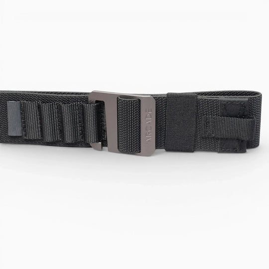 The Arcade Belts Hardware Alu is a black nylon low-profile belt with a metal buckle, shown on a white background. It features reinforced stitching and looped sections for extra durability, making it ideal for travel enthusiasts.