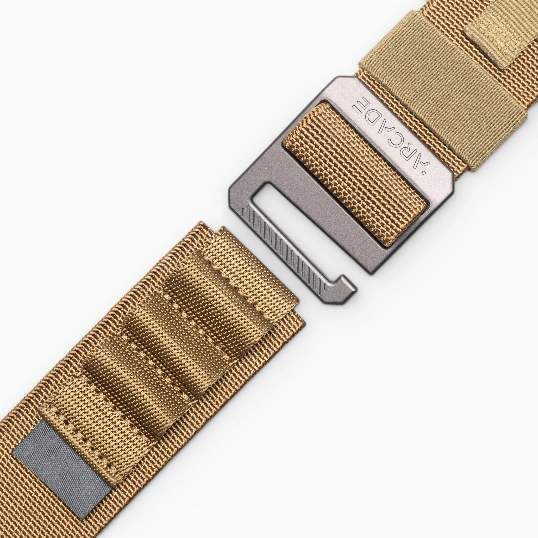 A close-up of the tan nylon Arcade Belts Hardware Alu belt with a metal buckle, set against a white background; the buckle and strap are partially separated.
