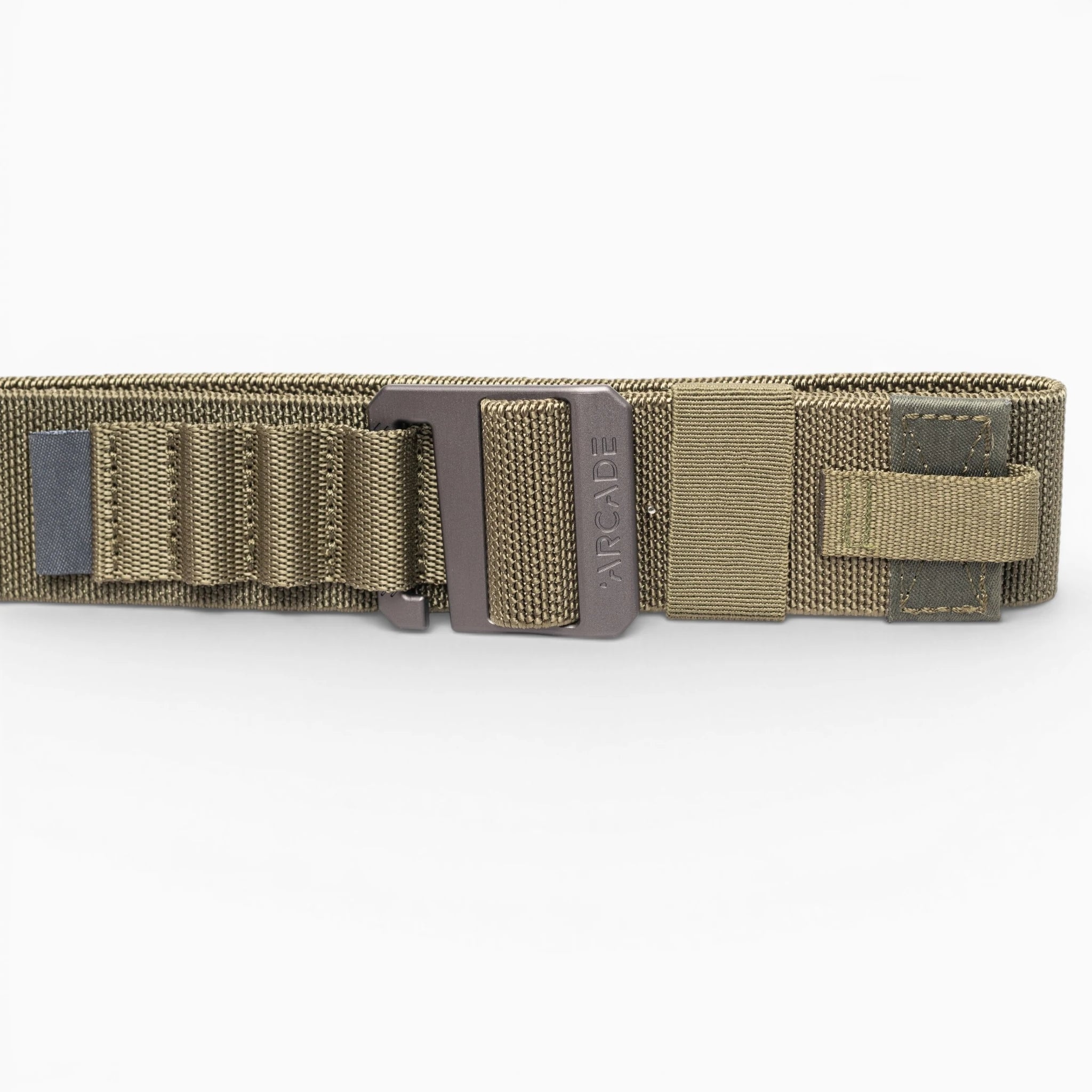 A close-up of the olive green Arcade Belts Hardware Alu tactical belt with a metal buckle, reinforced stitching, webbing loops, and Velcro strap. This low-profile belt offers durability and comfort against a white background.
