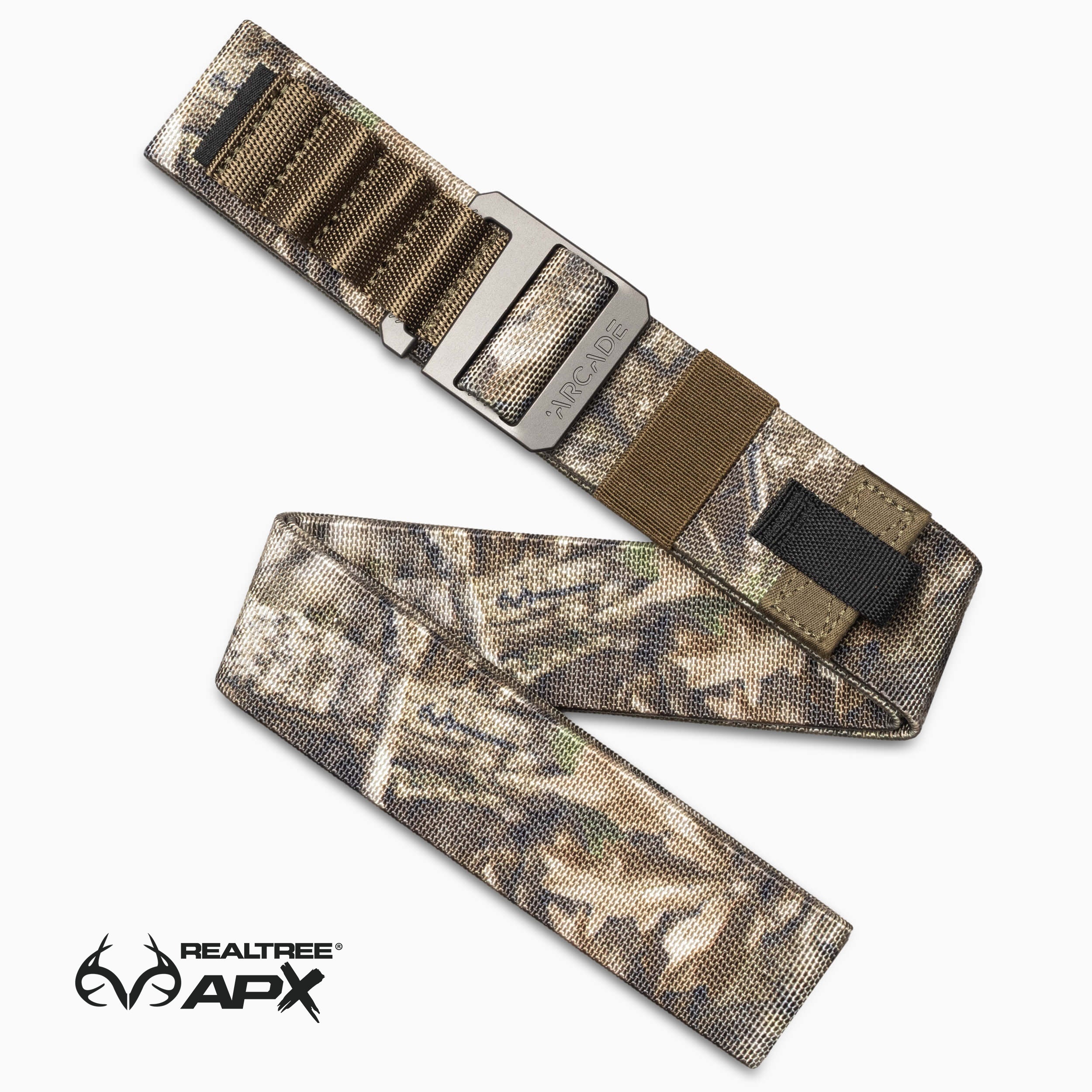 The image features a camouflage-patterned Arcade Belts Hardware Alu belt, coiled and open, with a low-profile aircraft-grade aluminum buckle. The Realtree APX logo is visible in the bottom left corner.