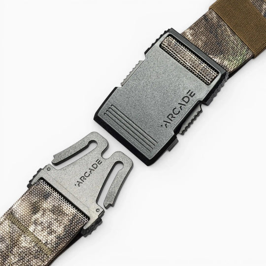 Two segments of the Arcade Belts Hardware low profile belt with a black plastic buckle, both engraved with the Arcade Belts name, are shown against a white background.