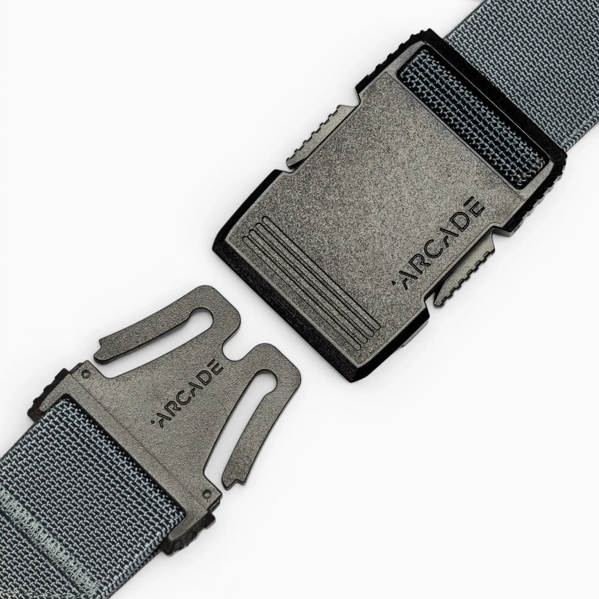 Close-up of a grey fabric Arcade Belts Hardware belt with a black plastic buckle, both parts separated and facing each other, showcasing the product’s superior strength and modern style.