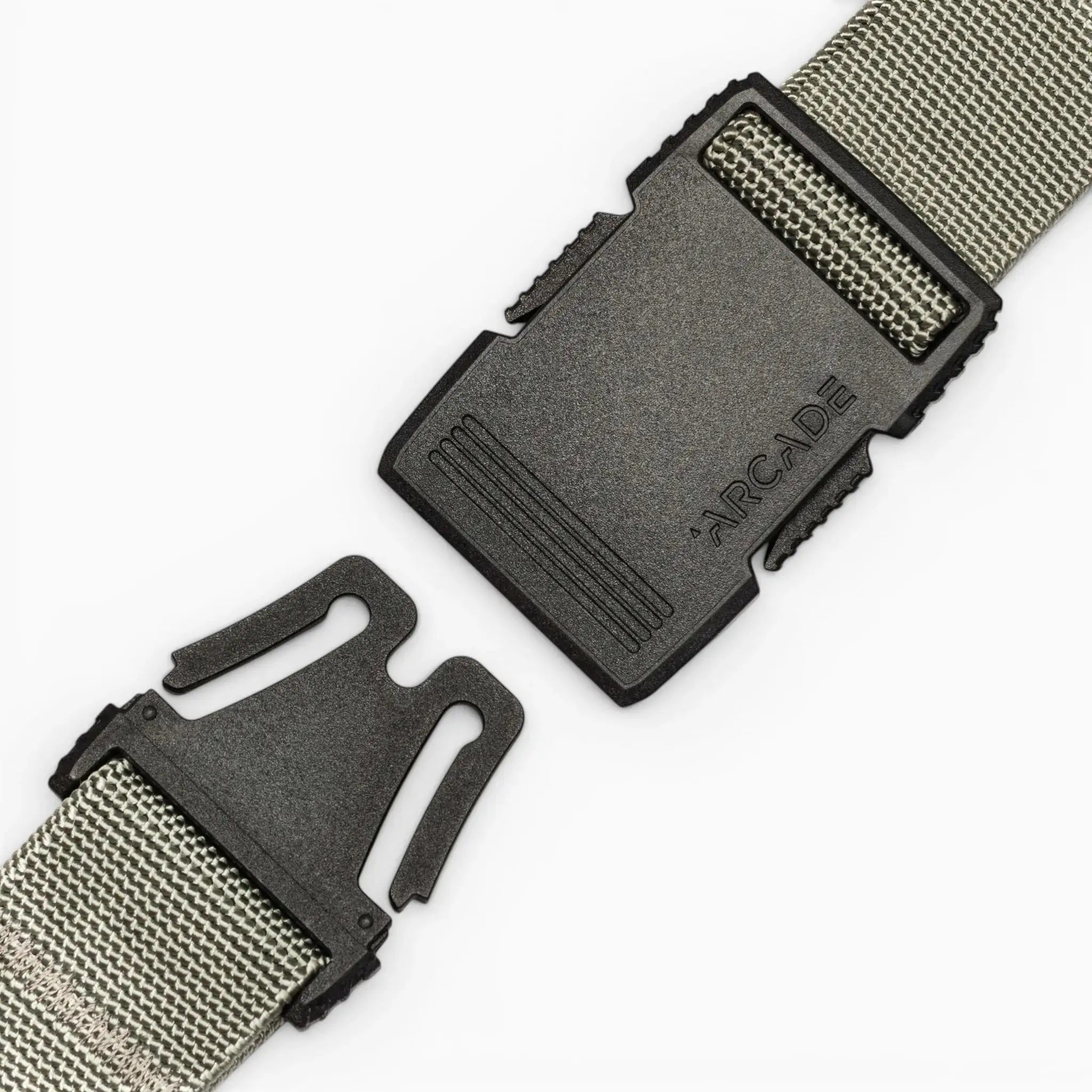 A close-up of the gray Arcade Belts Hardware belt features a black plastic buckle with "ARCADE" embossed, shown partially unclasped against a plain white background.