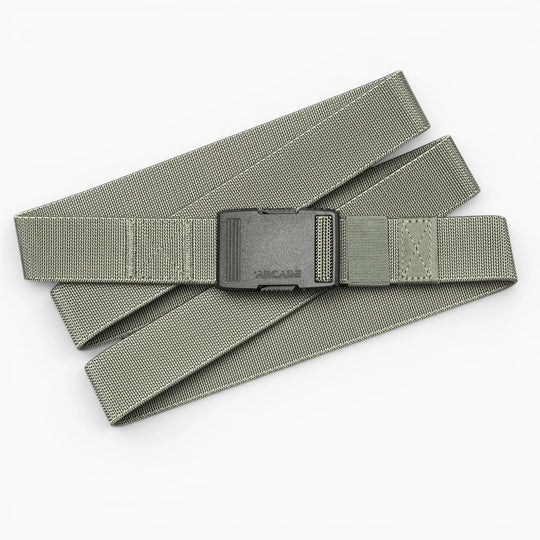 The Arcade Belts Hardware is a gray fabric belt with a black plastic buckle, laid flat on a white background. Adjustable and minimalist, it's designed for durability and superior strength.