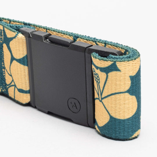 A close-up of the Arcade Belts Island Collection belt, featuring a black rectangular buckle and a yellow strap with teal floral patterns, embodies the Aloha spirit against a plain white background.