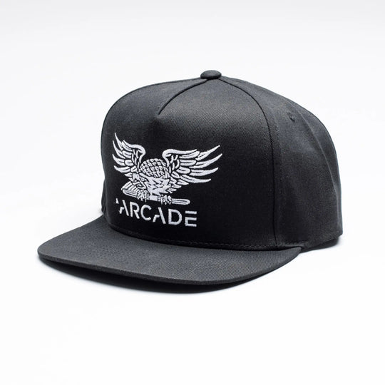 The Arcade High Crown Hat by Arcade Belts is a black snapback cap with a white embroidered eagle above ARCADE on the front, inspired by the bold style of Arcade Belts and shown against a plain white background.