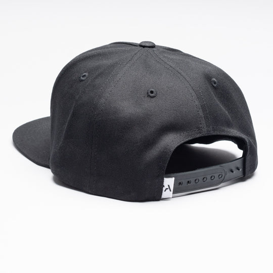 The Arcade High Crown Hat by Arcade Belts is a black snapback cap shown from the back, featuring an adjustable strap with stretch webbing and a small white tag. The hat is displayed on a plain white background.