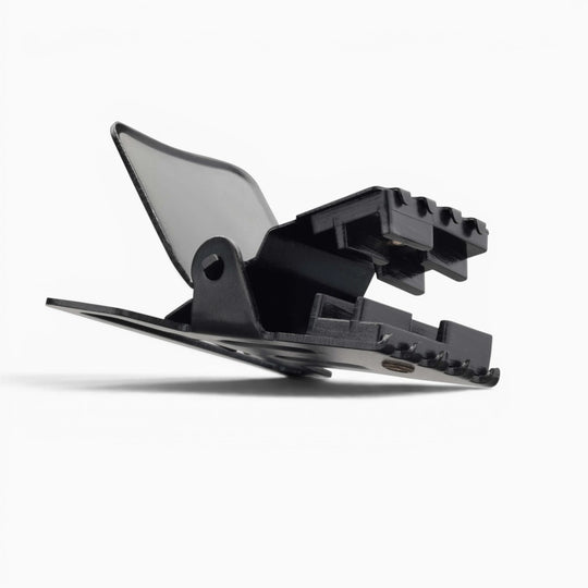 The Jessup hair clip by Arcade Belts, made of black plastic with a spring mechanism and plastic buckle, is shown open from the side view against a plain white background.