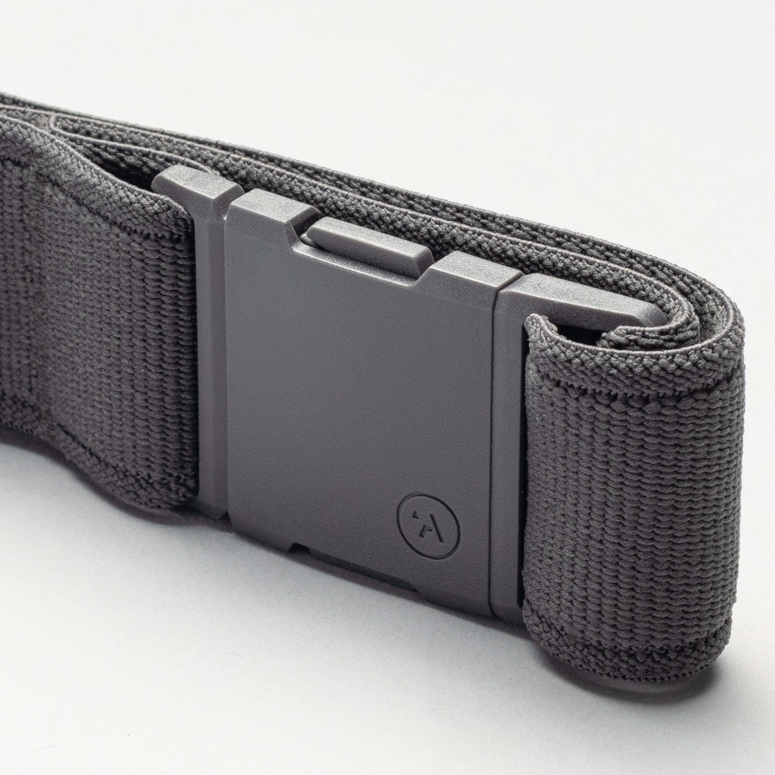 A close-up of the Arcade Belts Keep Tahoe Blue nylon belt in black, featuring a rectangular matte plastic buckle, neatly rolled on a light gray surface—ideal for showing support for Lake Tahoe’s environment.