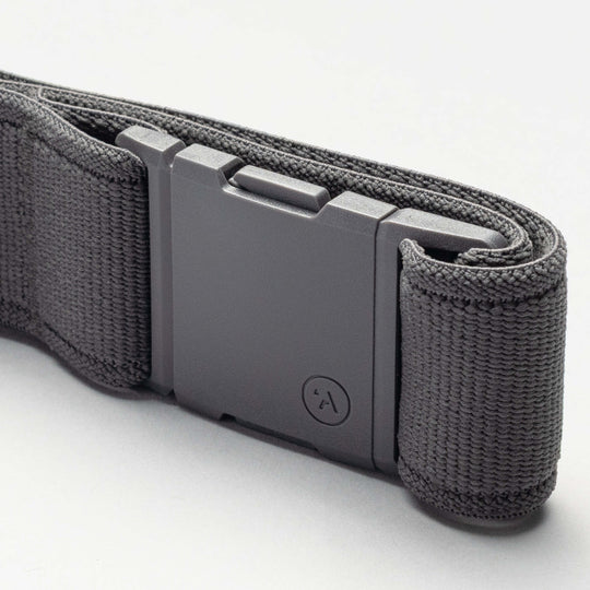 A close-up of the Arcade Belts Keep Tahoe Blue nylon belt in black, featuring a rectangular matte plastic buckle, neatly rolled on a light gray surface—ideal for showing support for Lake Tahoe’s environment.