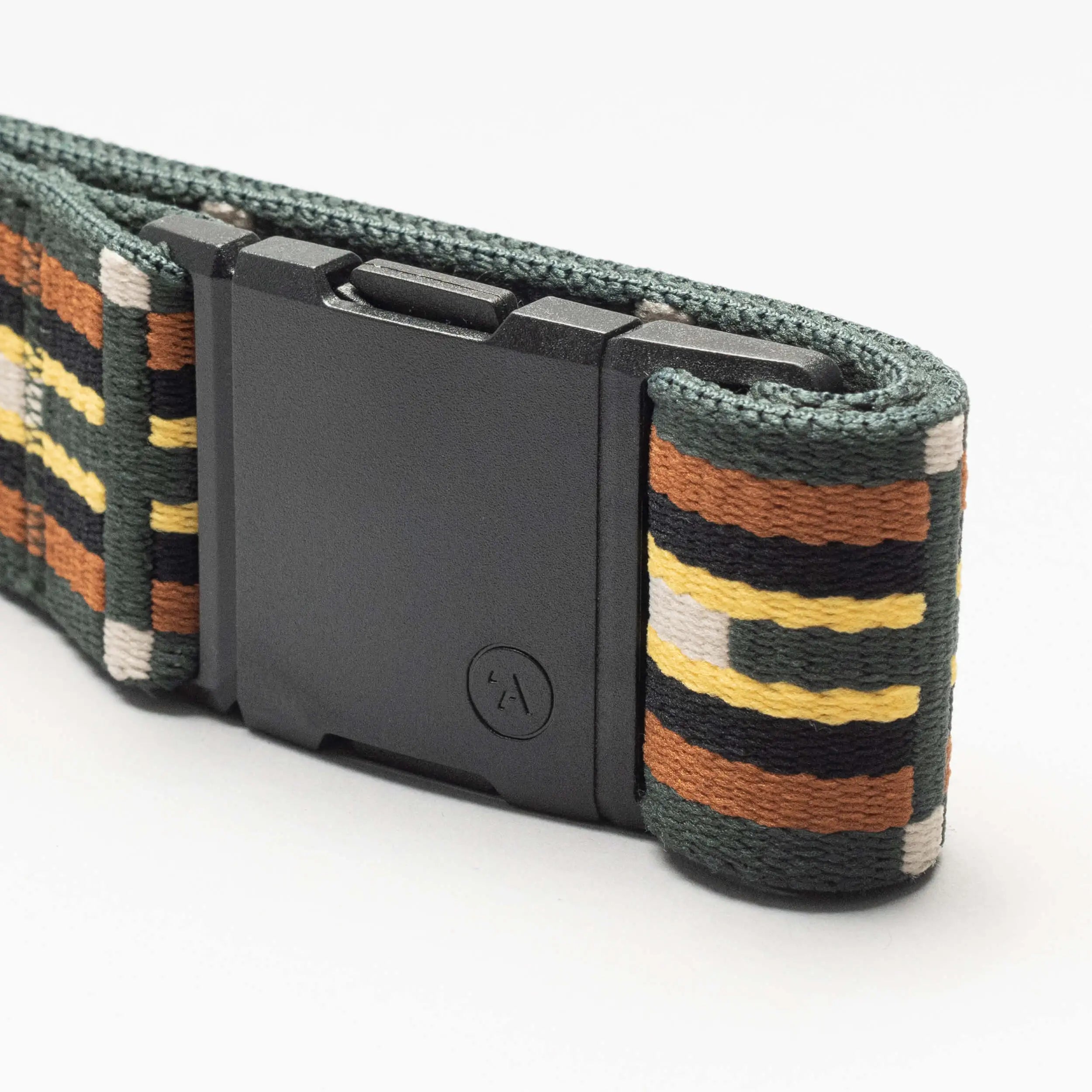 A close-up of the Arcade Belts Vernan Kee travel belt, featuring a dark rectangular buckle and a striped pattern in green, black, mustard yellow, brown, and gray.