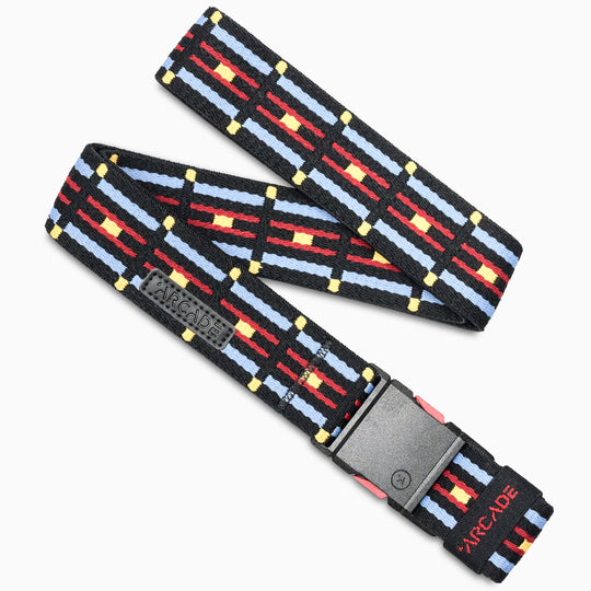 The Vernan Kee by Arcade Belts is a woven low-profile belt with a black, white, red, and yellow geometric pattern, comfy stretch webbing, a black buckle printed with Arcade in red, and a small black Arcade patch—great for travel.