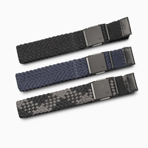 The Arcade Belts Futureweave Kit features three woven belts—black, navy blue, and black-grey pattern—each with a matte black rectangular buckle, offering ultimate comfort and 4-way stretch flexibility.