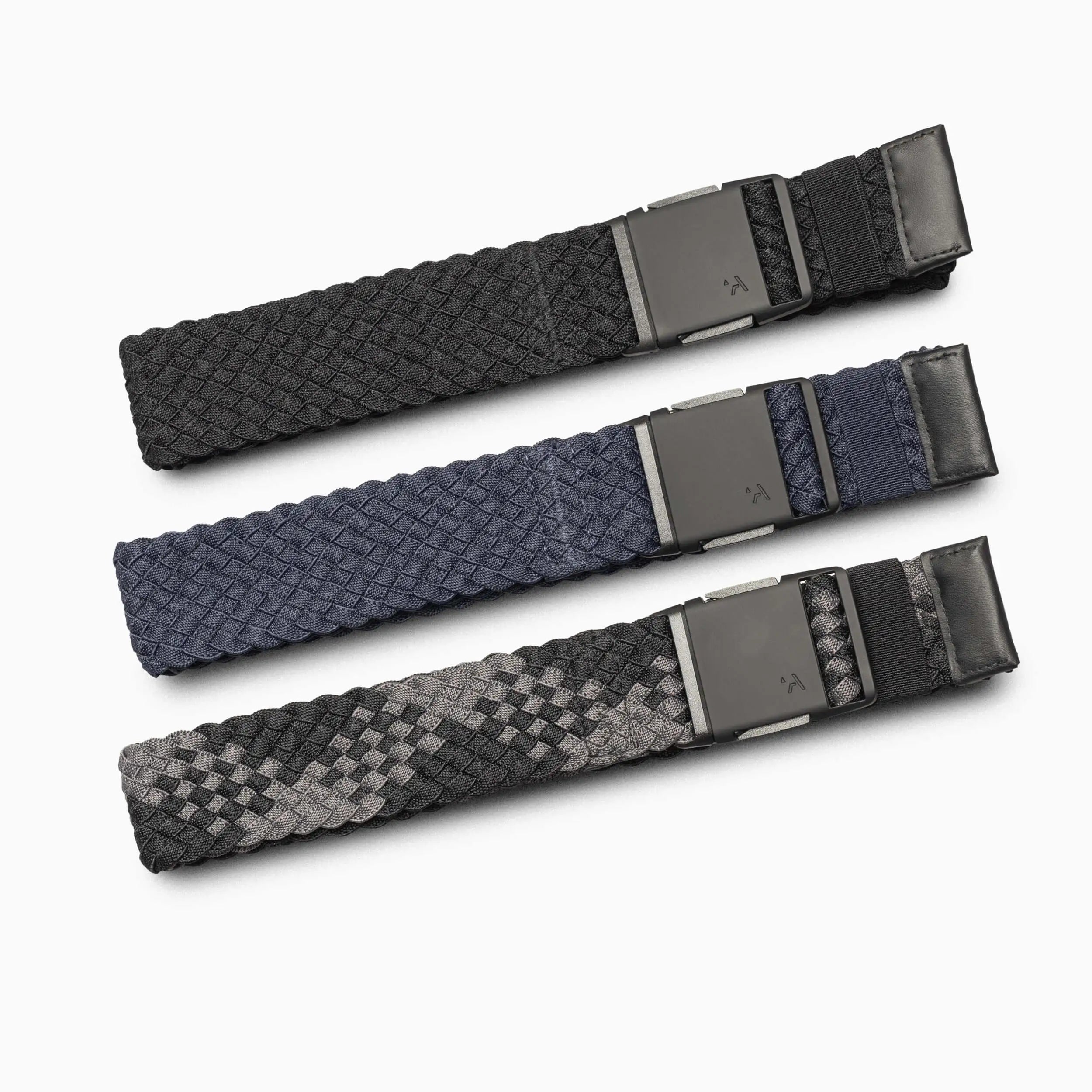 The Arcade Belts Futureweave Kit features three woven belts—black, navy blue, and black-grey pattern—each with a matte black rectangular buckle, offering ultimate comfort and 4-way stretch flexibility.