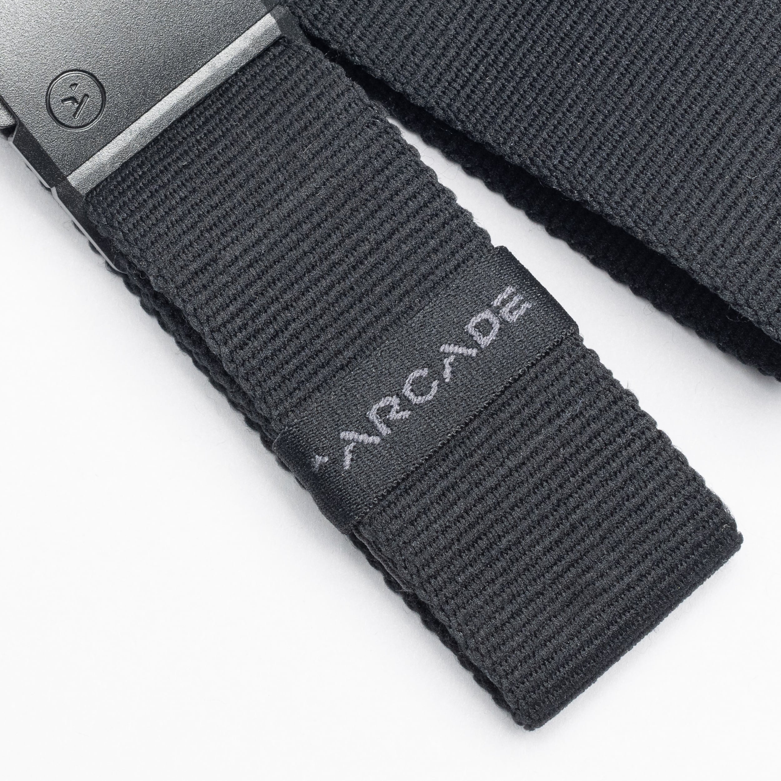 Close-up of a black low profile Belt Loopkeepers from Arcade Belts with a black metal buckle and ARCADE embroidered in white, perfect for travelers who value both style and functionality.