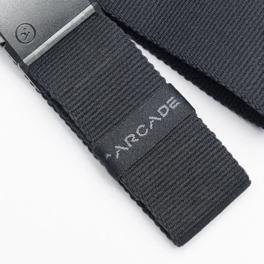 Close-up of a black low profile Belt Loopkeepers from Arcade Belts with a black metal buckle and ARCADE embroidered in white, perfect for travelers who value both style and functionality.