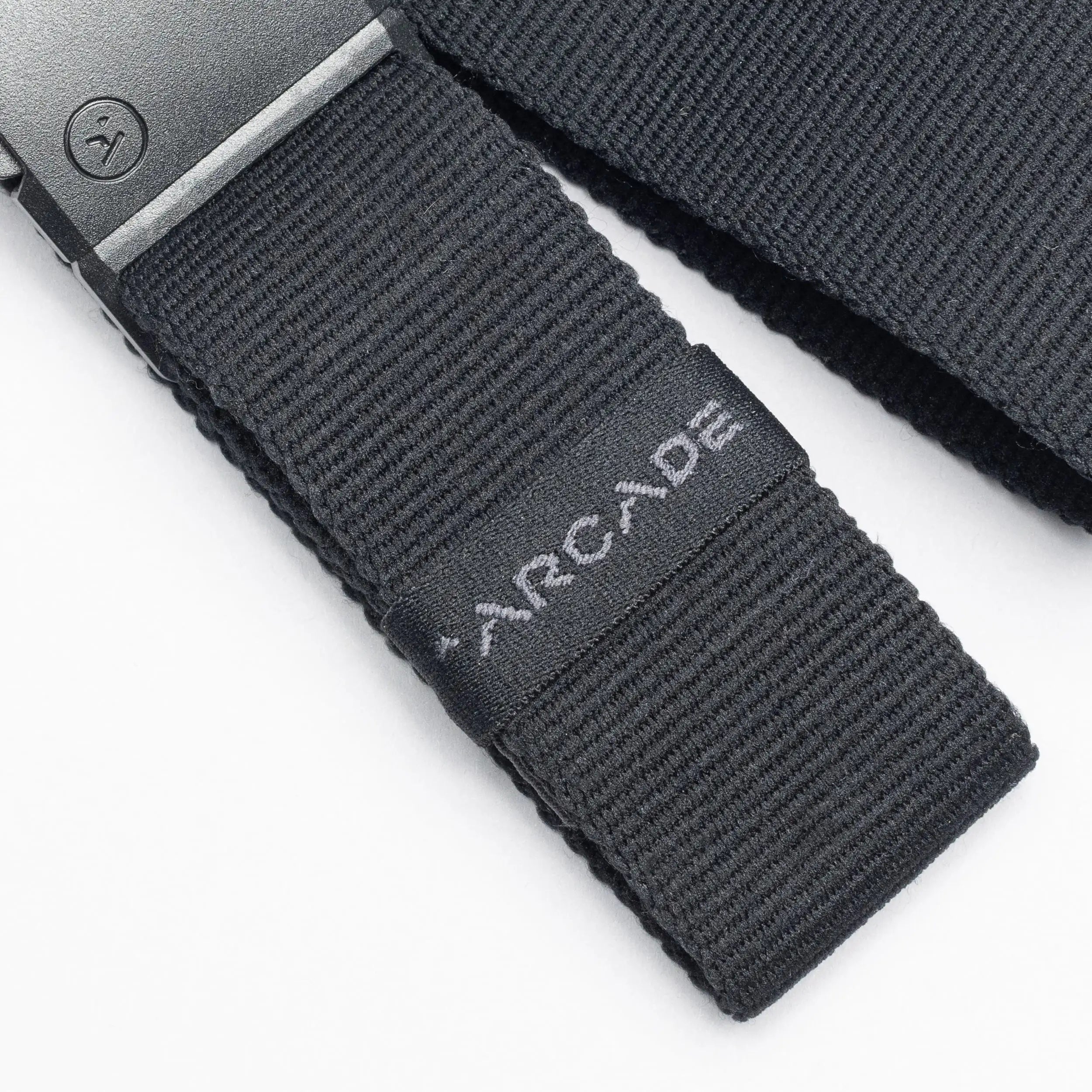 Close-up of a black low profile Belt Loopkeepers from Arcade Belts with a black metal buckle and ARCADE embroidered in white, perfect for travelers who value both style and functionality.
