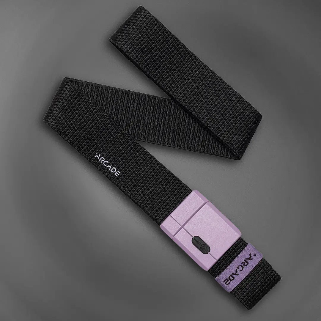 A black woven belt with a purple buckle, featuring the brand name ARCADE printed in white on the belt and engraved on the buckle, displayed on a gray background.