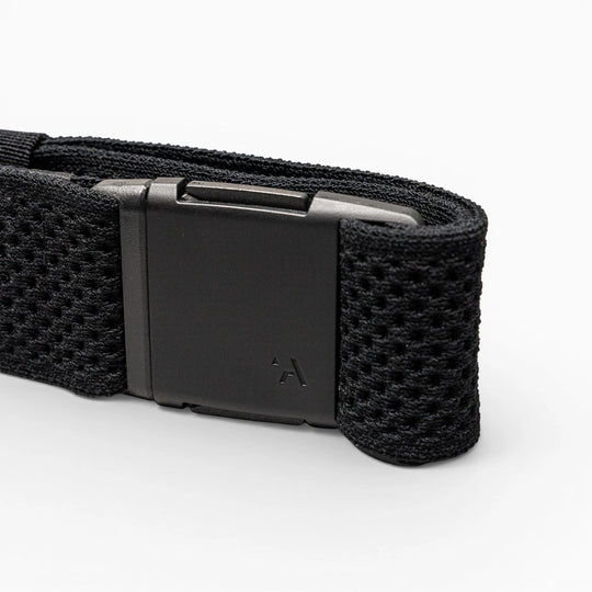 A close-up of the Arcade Belts Momentum strap in black shows its textured, mesh-like webbing and a matte black rectangular buckle with a small logo, all displayed against a light gray background.