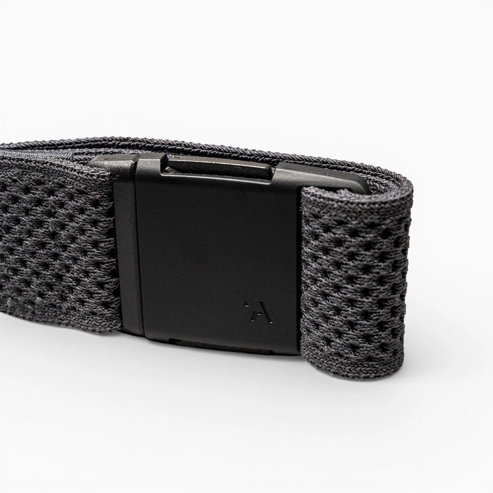 A close-up of the Arcade Belts Momentum strap shows its black textured fabric and rectangular black plastic buckle on a light grey background, highlighting its signature low-profile design.