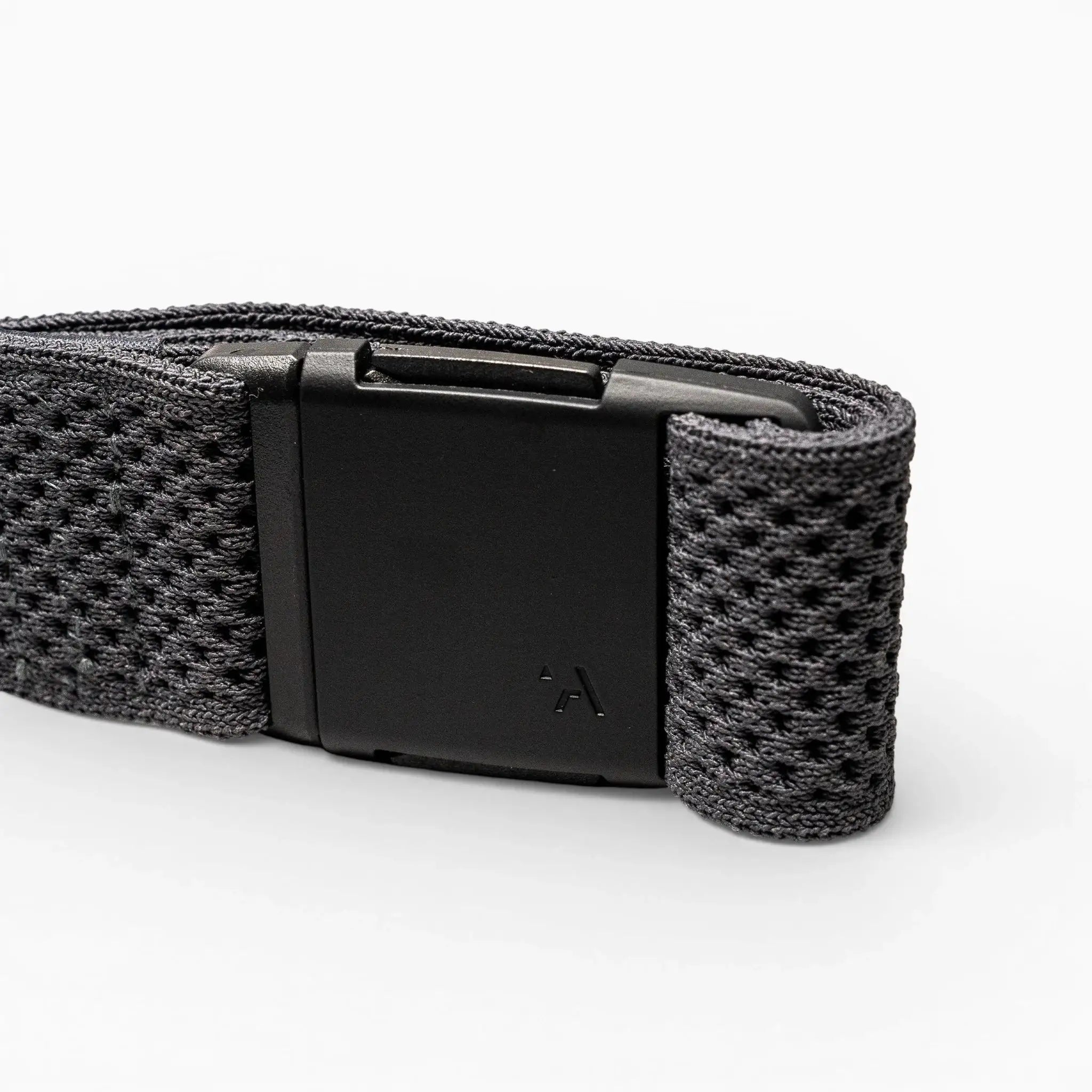 A close-up of the Arcade Belts Momentum strap shows its black textured fabric and rectangular black plastic buckle on a light grey background, highlighting its signature low-profile design.