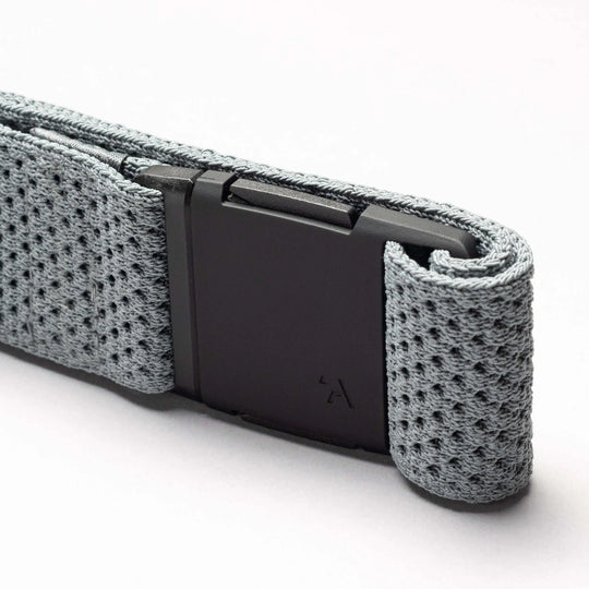 A close-up of the gray Arcade Belts Momentum belt, featuring a black rectangular buckle and textured stretch webbing, is displayed against a plain white background.