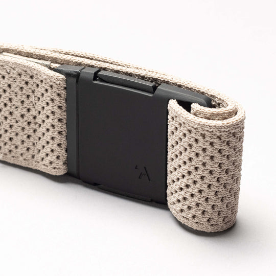 A close-up of the Arcade Belts Momentum: a beige, textured woven low profile belt with a matte black rectangular buckle, set against a plain light background.