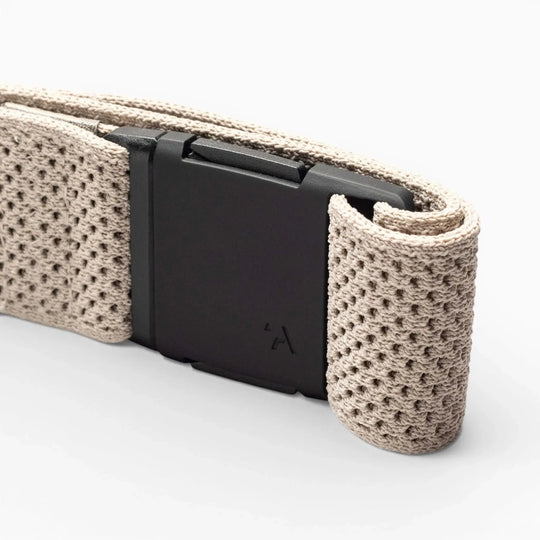 A close-up of the Arcade Belts Momentum: a beige, textured woven low profile belt with a matte black rectangular buckle, set against a plain light background.