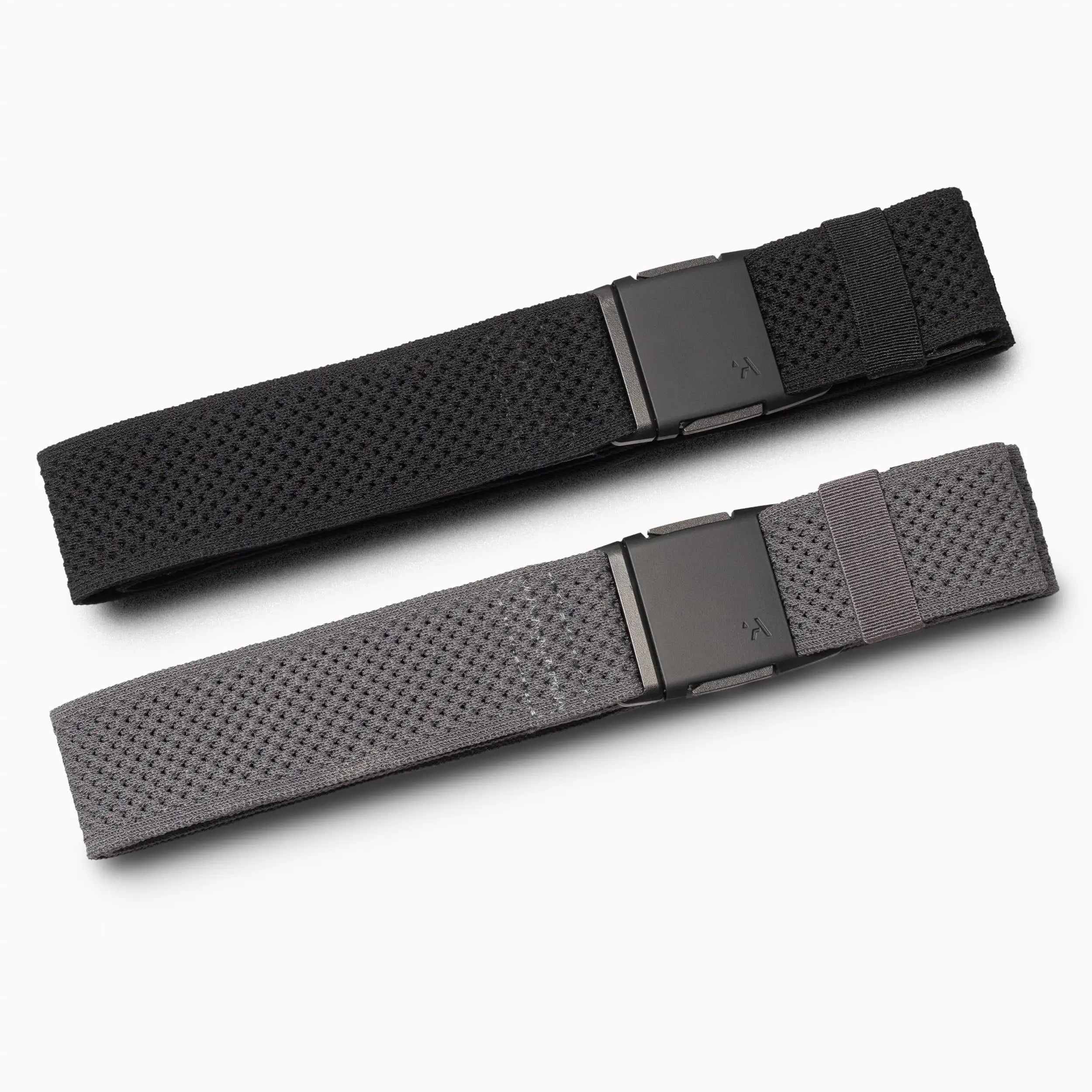 The Arcade Belts Momentum Kit displays two woven fabric belts, black and gray, laid side by side. Each features a rectangular black buckle with a minimalist, low-profile design, set against a white background.