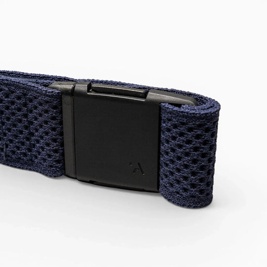 A close-up of the Arcade Belts Momentum, a dark blue elastic stretch belt with a black rectangular plastic buckle, set against a plain light gray background.