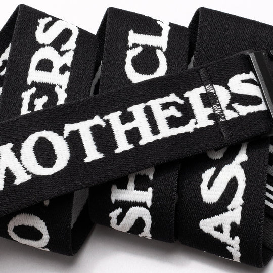 A close-up of the Arcade Belts Mothership Classic, a black stretch webbing low-profile belt with bold white MOTHERS text and overlapping letters, finished with a sleek black plastic buckle.