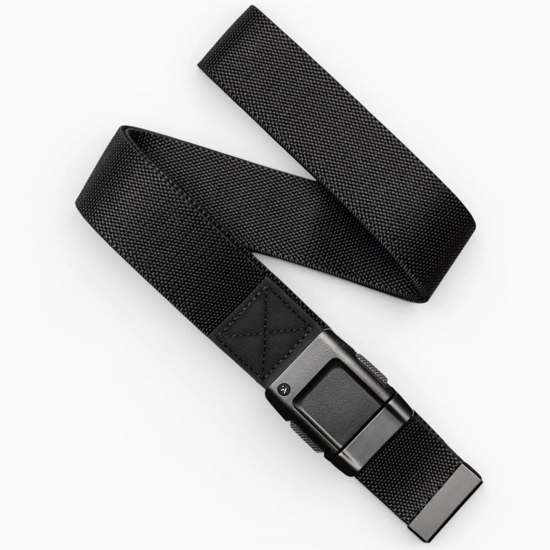 The Arcade Belts Motion is a black woven fabric belt with a rectangular black buckle, pictured loosely coiled on a white background—offering modern style and everyday comfort.