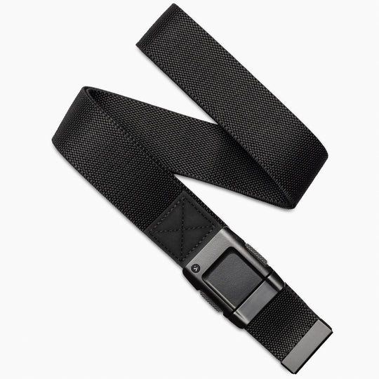 The Arcade Belts Motion is a black stretch webbing belt with a rectangular black buckle, shown diagonally on a white background. Partially coiled, it highlights both the buckle and end for a sleek, modern look.