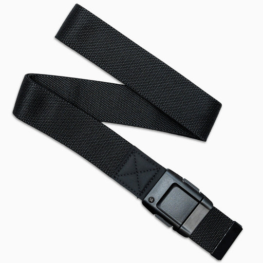 The Arcade Belts Motion Kit is a black nylon low-profile belt with stretch webbing for comfort and a sturdy rectangular metal buckle, shown on a white background in a slight zigzag layout.
