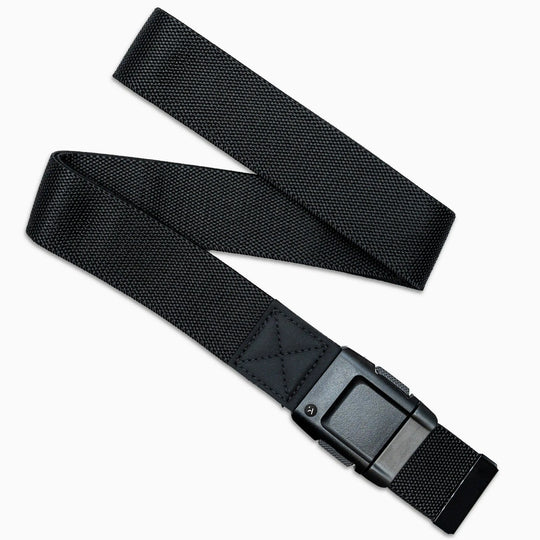 The Arcade Belts Motion Kit is a black nylon low-profile belt with stretch webbing for comfort and a sturdy rectangular metal buckle, shown on a white background in a slight zigzag layout.