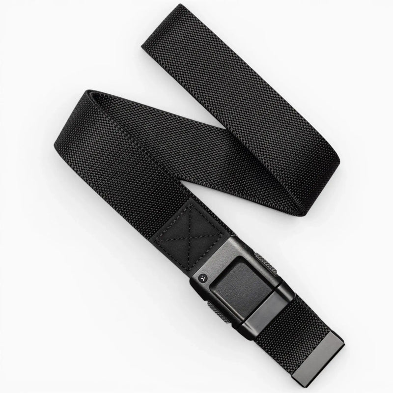 The Arcade Belts Motion is a black woven fabric belt with a rectangular black buckle, pictured loosely coiled on a white background—offering modern style and everyday comfort.