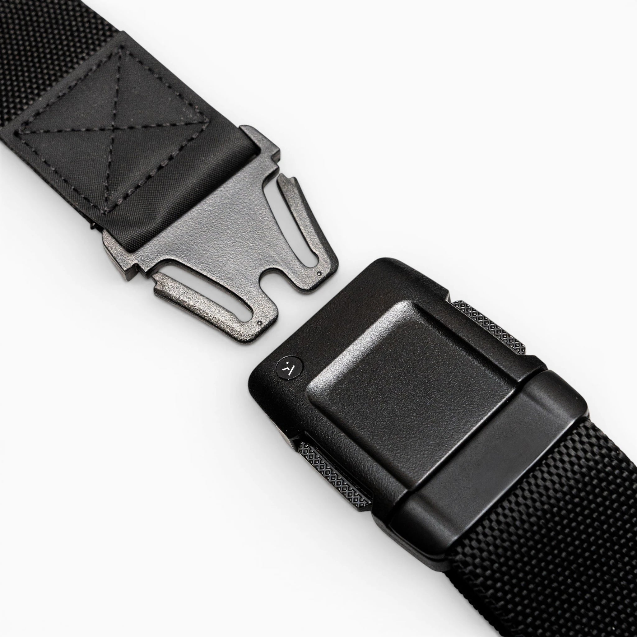 Close-up of the Arcade Belts Motion, a black tactical belt with a metal quick-release buckle, showcasing its modern style and comfortable fit, partially unfastened on a white surface.