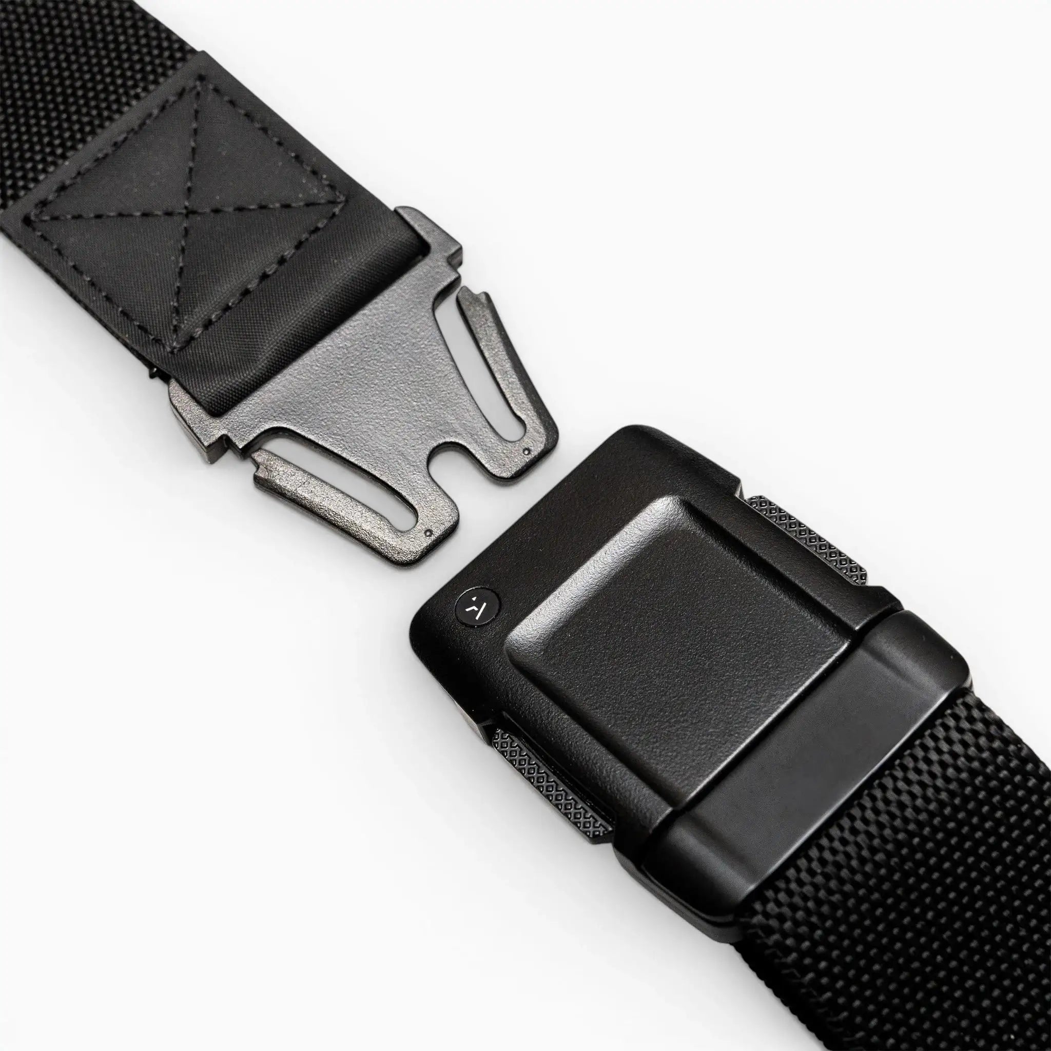 Close-up of the Arcade Belts Motion, a black tactical belt with a metal quick-release buckle, showcasing its modern style and comfortable fit, partially unfastened on a white surface.