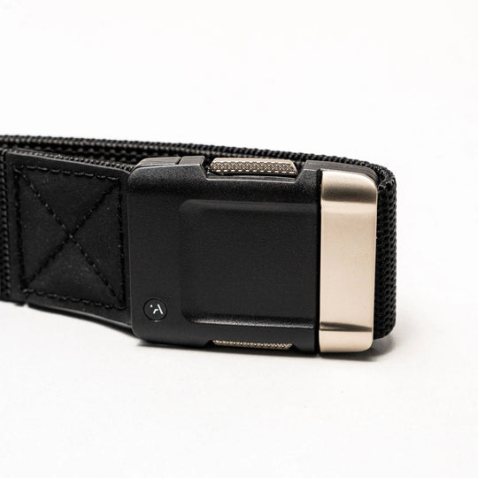 A close-up of the Arcade Belts Motion elastic stretch belt, shown on a light background with a rectangular matte black buckle and metallic silver accent.