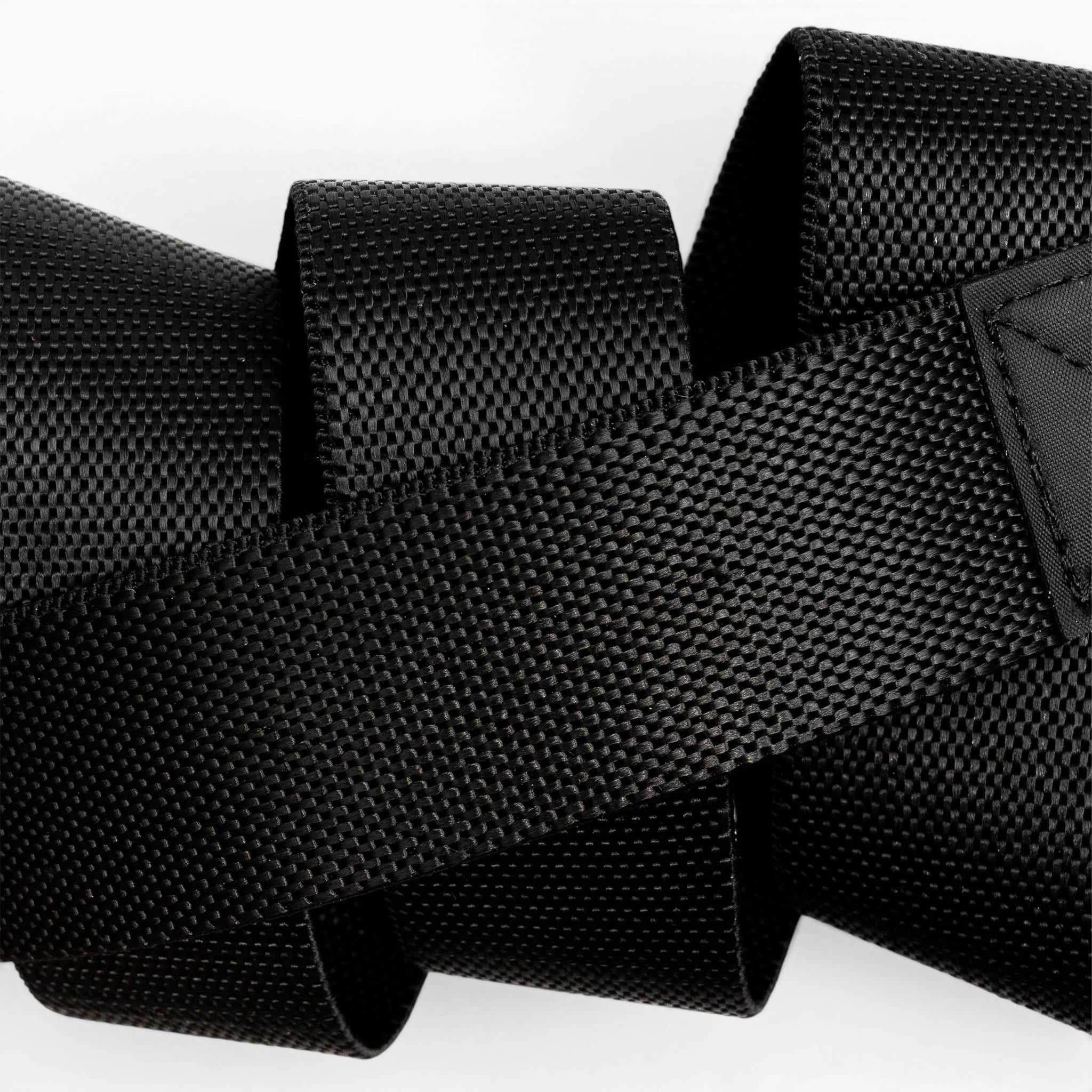 A close-up of the black Motion strap by Arcade Belts, featuring a woven texture and overlapping loops, set against a white background.