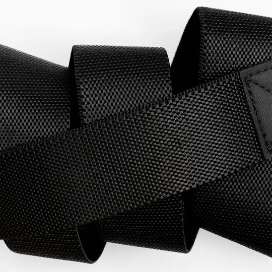 A close-up of the black Motion strap by Arcade Belts, featuring a woven texture and overlapping loops, set against a white background.