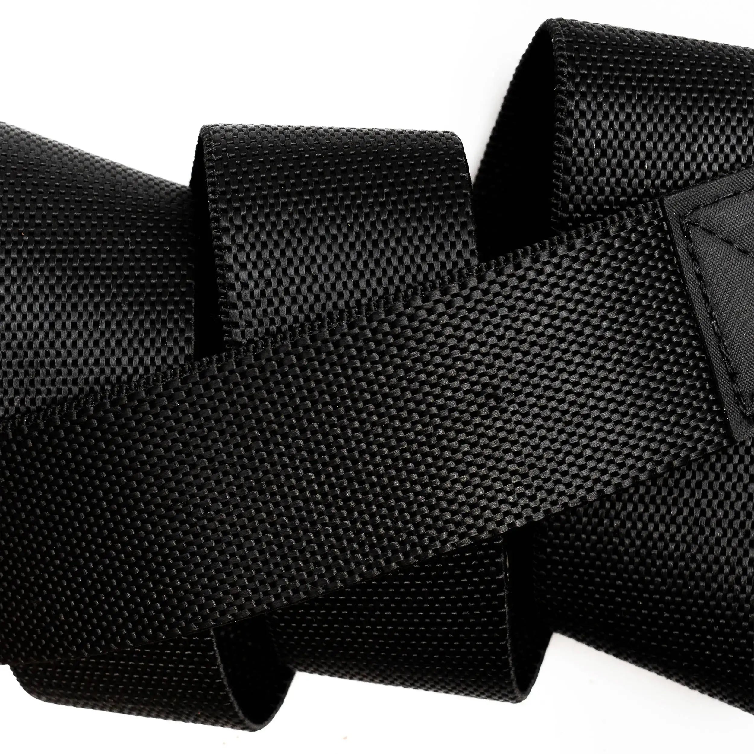 Close-up of a thick, black Motion woven nylon strap by Arcade Belts with textured surface, coiled and overlapping on a white background—ideal for a modern belt that ensures comfort.