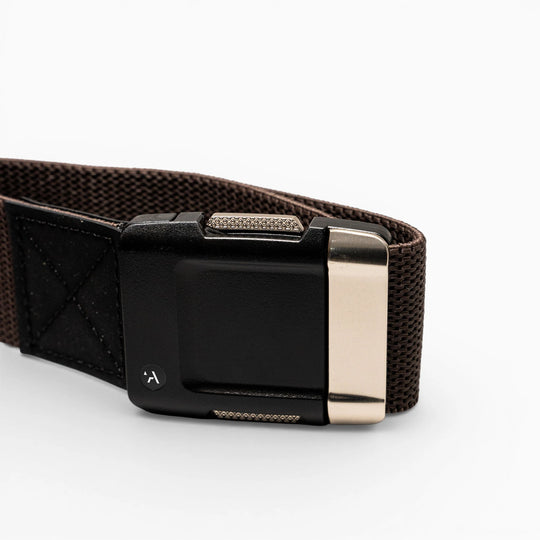 A close-up of the Arcade Belts Motion: a brown fabric belt with a black rectangular plastic buckle and metallic silver clasp, set against a plain white background—perfect as a low-profile, everyday accessory.