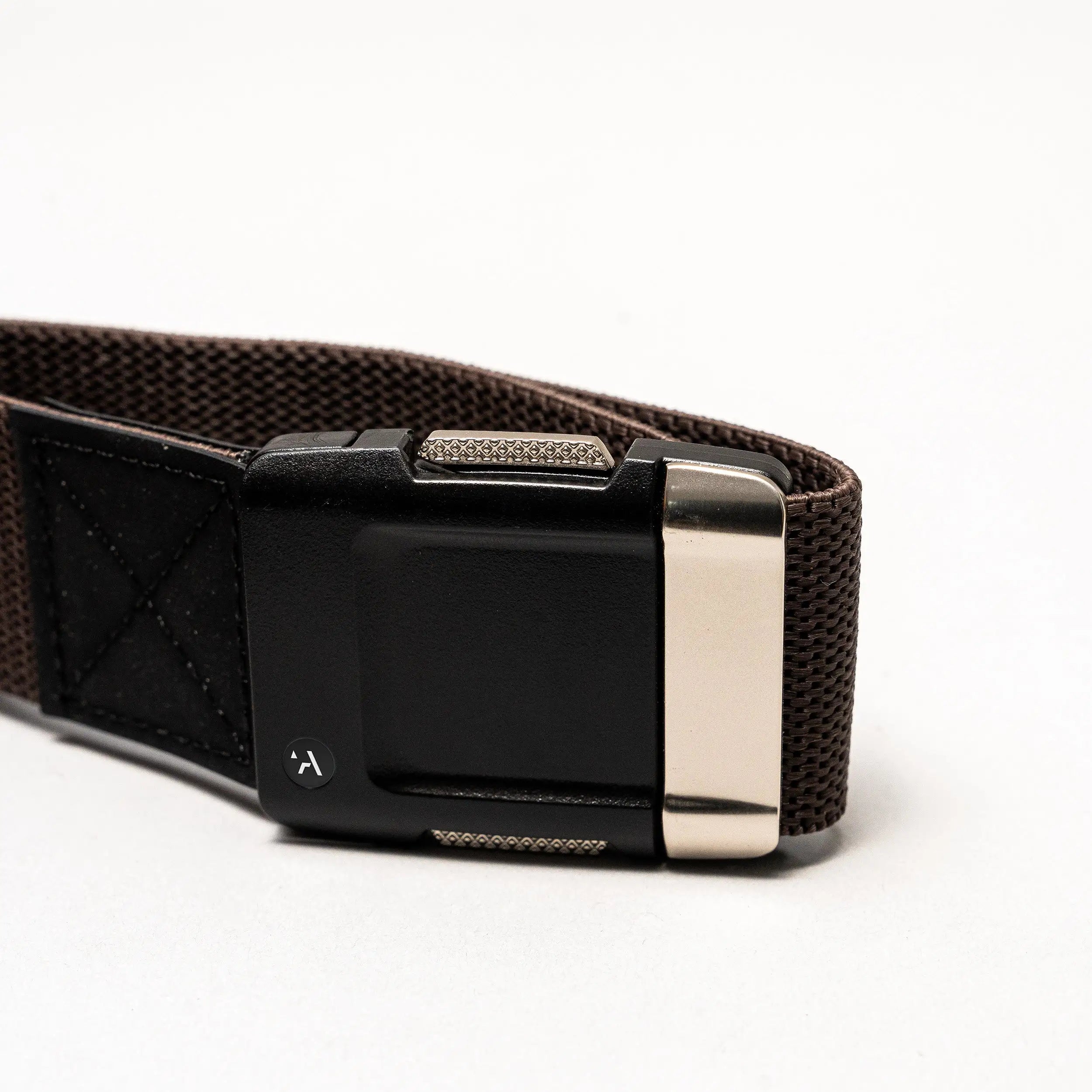 A close-up of the Arcade Belts Motion: a brown fabric belt with a black rectangular plastic buckle and metallic silver clasp, set against a plain white background—perfect as a low-profile, everyday accessory.